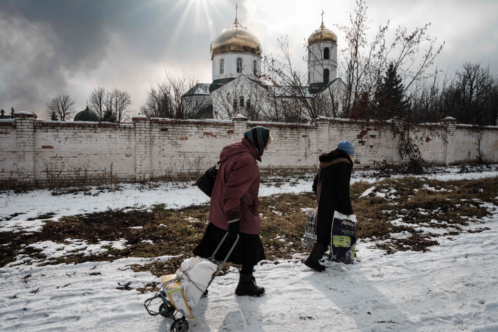 Orthodox Christians leave after the Sunday prayer at the Church of All Saints as sounds and vibrations of shelling continue in Bakhmut on February 5, 2023, amid the Russian invasion of Ukraine. (Photo by YASUYOSHI CHIBA / AFP)