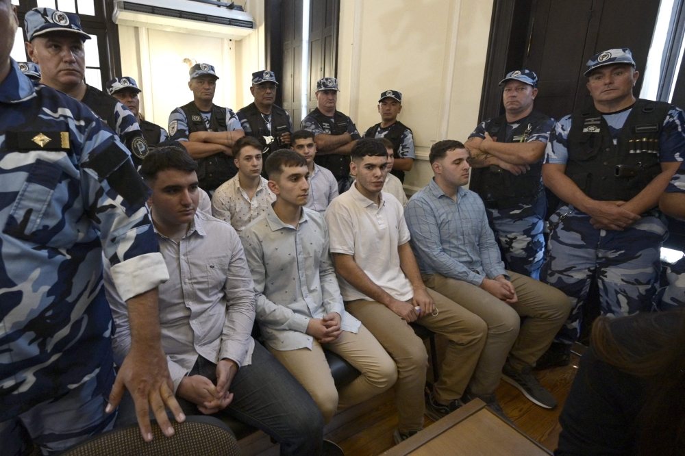 Defendants accused of the murder of Fernando Baez Sosa Ciro Pertossi (front, L), Matias Benicelli (front, 2-L), Blas Cinalli (front, 2-R), Lucas Pertossi (front, R), Ayrton Viollaz (back, L), Maximo Thomsen (back, 2-L), Enzo Comelli (back, 2-R) and Luciano Pertossi (back, R) hear their sentence at the court in Dolores, Buenos Aires province, Argentina, on February 6, 2023. (Photo by JUAN MABROMATA / AFP)