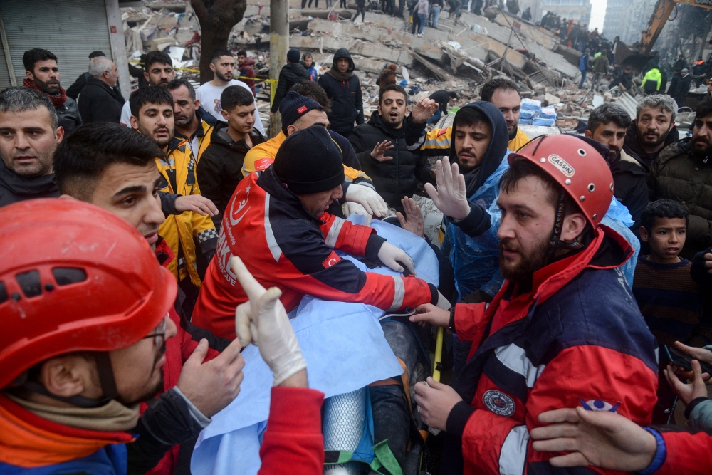Rescue workers and volunteers pull out a survivor from the rubble in Diyarbakir on February 6, 2023, after a 7.8-magnitude earthquake struck the country's south-east. (Photo by ILYAS AKENGIN / AFP)