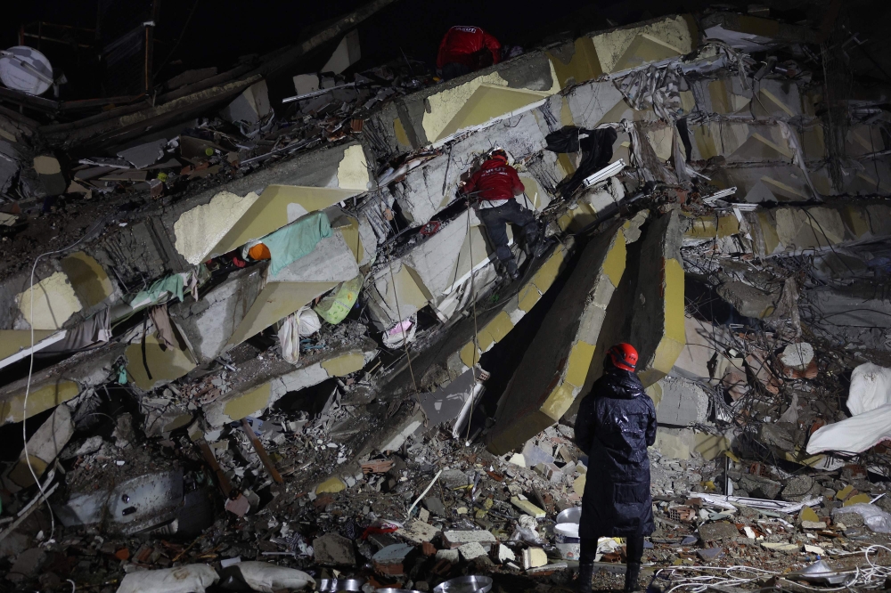 Rescuers search for victims and survivors amidst the rubble of collapsed buildings in Kahramanmaras, Turkey on February 7, 2023. (Photo by Adem Altan / AFP)
 