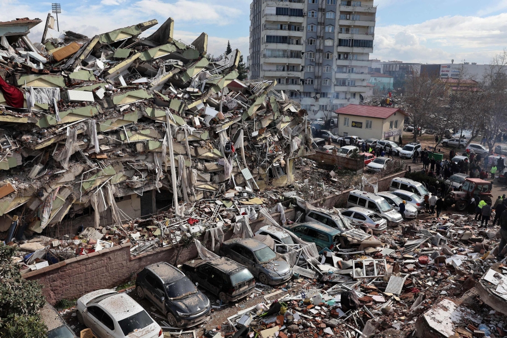 Rescuers and civilians look for survivors under the rubble of collapsed buildings in Kahramanmaras, close to the quake's epicentre, the day after a 7.8-magnitude earthquake struck the country's southeast, on February 7, 2023. Photo by Adem ALTAN / AFP