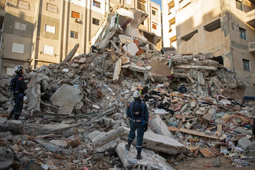 Russian rescue personnel search for survivors and victims under the rubble of a collapsed building in the town of Jableh in Syria's northwestern province of Latakia. (Photo by AFP)