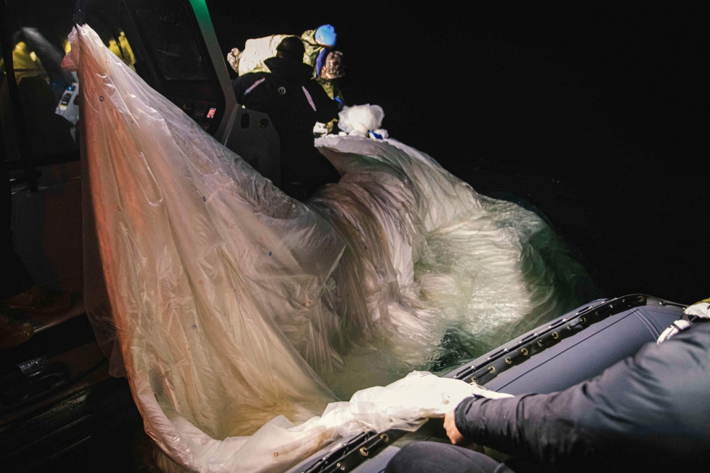This picture provided by the US Navy shows sailors assigned to Explosive Ordnance Disposal Group 2 recover a high-altitude surveillance balloon off the coast of Myrtle Beach, South Carolina, in the Atlantic ocean on February 5, 2023.