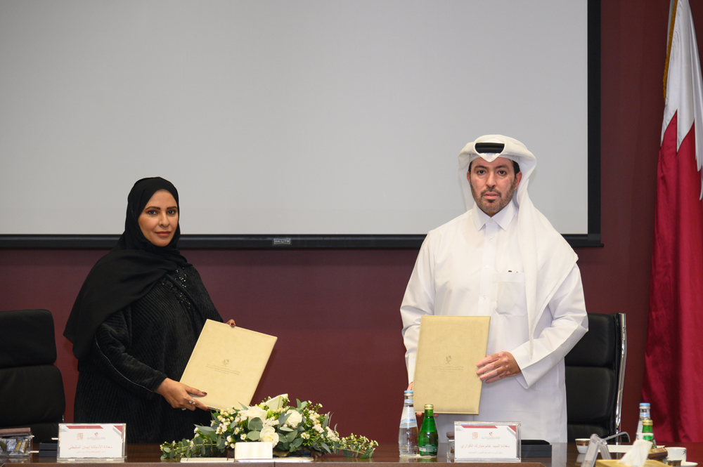 Assistant Undersecretary in the Ministry of Social Development and Family, Ghanem Mubarak Al Kuwari (right), and Executive Director of the Administrative and Financial Sector in Doha Institute for Graduate Studies, Iman Al Sulaiti, exchanging documents after signing the agreement.