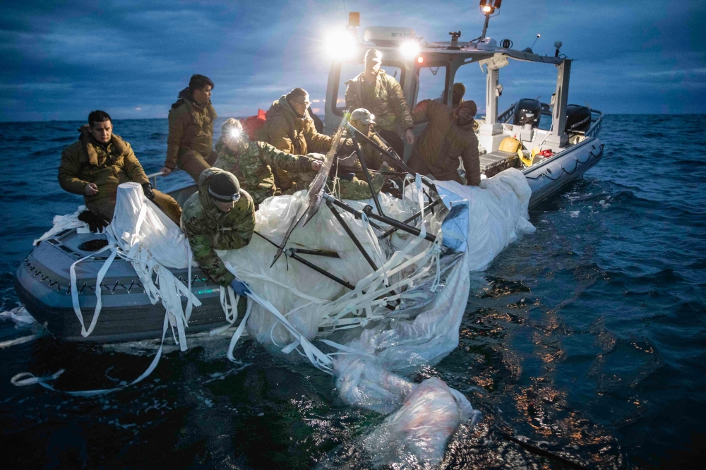 Sailors assigned to Explosive Ordnance Disposal Group 2 recover a high-altitude surveillance balloon off the coast of Myrtle Beach, South Carolina, on February 5, 2023.  (Photo by Petty Officer 1st Class Tyler Thompson / US NAVY / AFP)