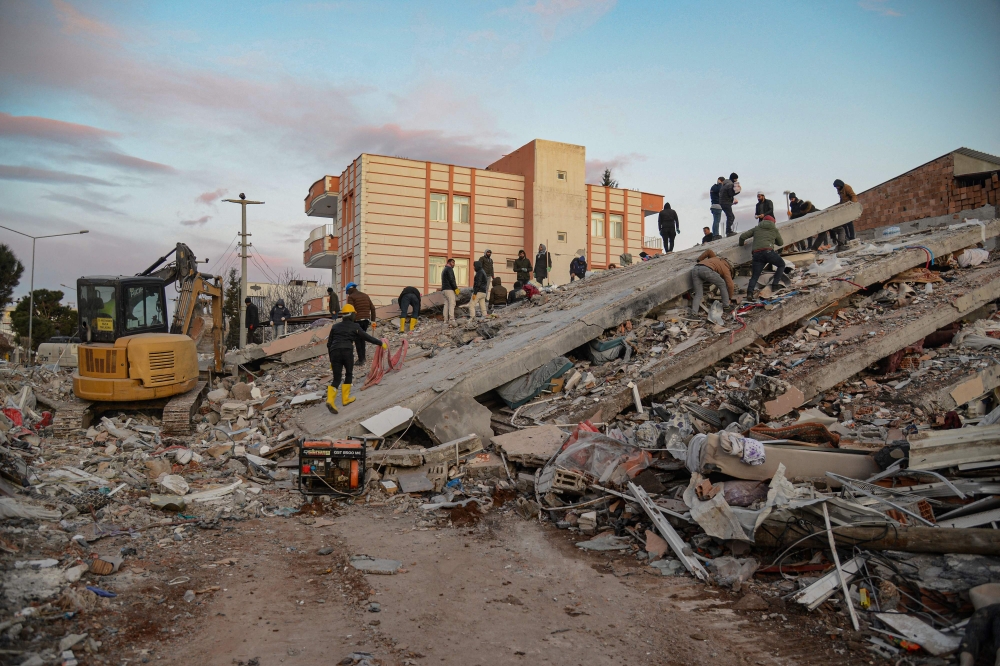 A photo taken on on February 8, 2023, shows residents and rescue personnel searching for victims and survivors through the rubble of collapsed buildings in Adiyaman, two days after a 7,8-magnitude earthquake struck southeast Turkey.  Photo by ILYAS AKENGIN / AFP