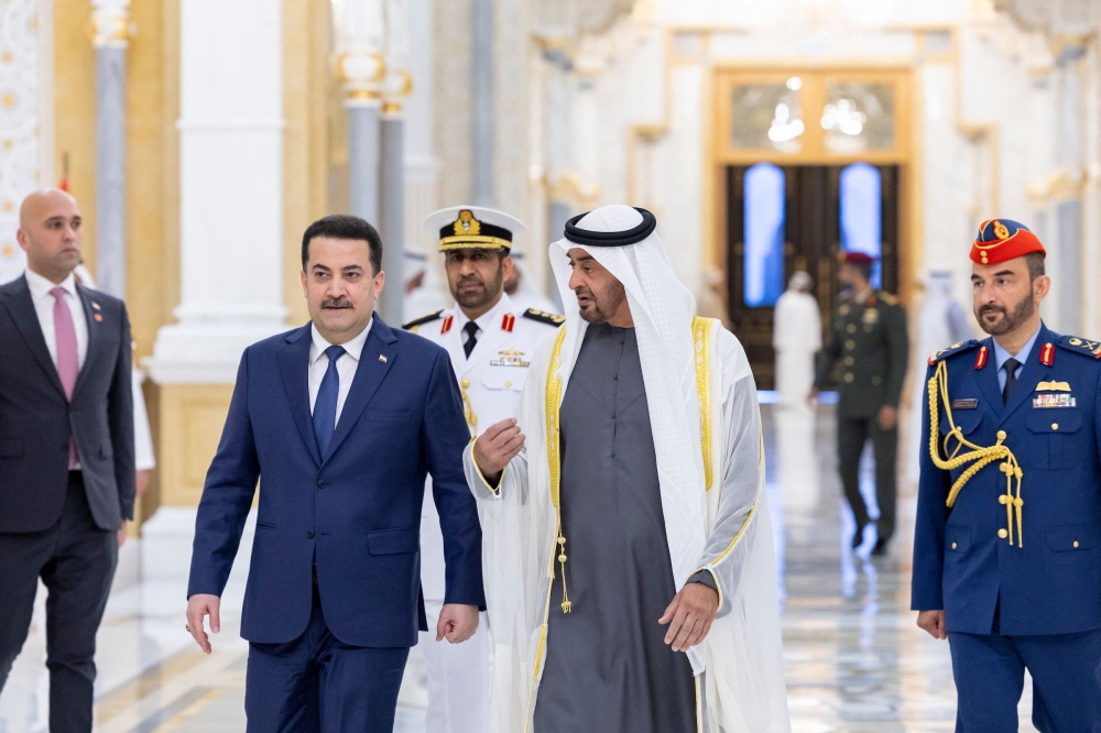 A handout picture released by the United Arab Emirates' presidential court shows Emirati President Sheikh Mohamed bin Zayed Al-Nahyan welcoming Iraq's Premier Mohamed Shia al-Sudani in Abu Dhabi on February 9, 2023. (Photo by UAE PRESIDENTIAL COURT / AFP)