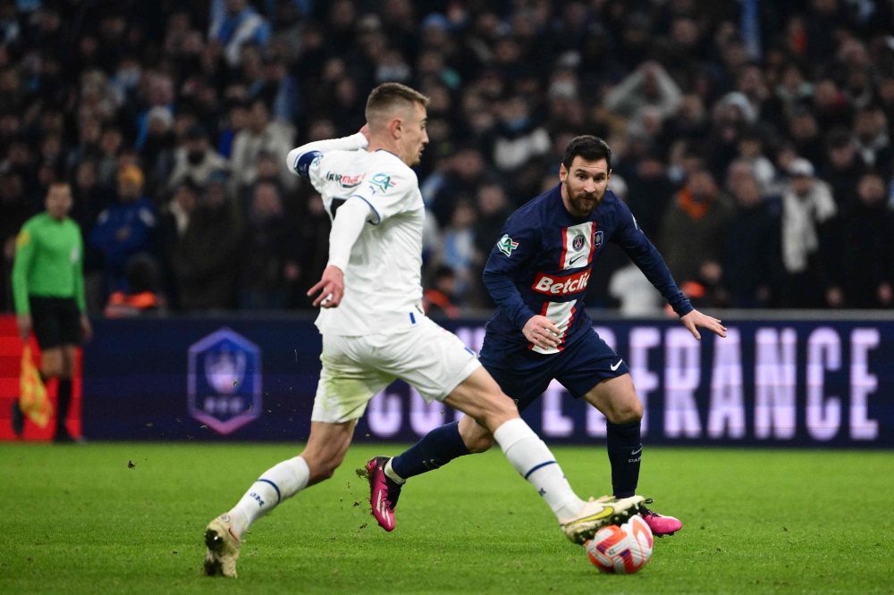 Marseille's French midfielder Valentin Rongier (L) fights for the ball with Paris Saint-Germain's Argentine forward Lionel Messi during the French Cup round of 16 football match between Olympique Marseille (OM) and Paris Saint-Germain (PSG) at Stade Velodrome in Marseille, southern France on February 8, 2023. (Photo by CHRISTOPHE SIMON / AFP)