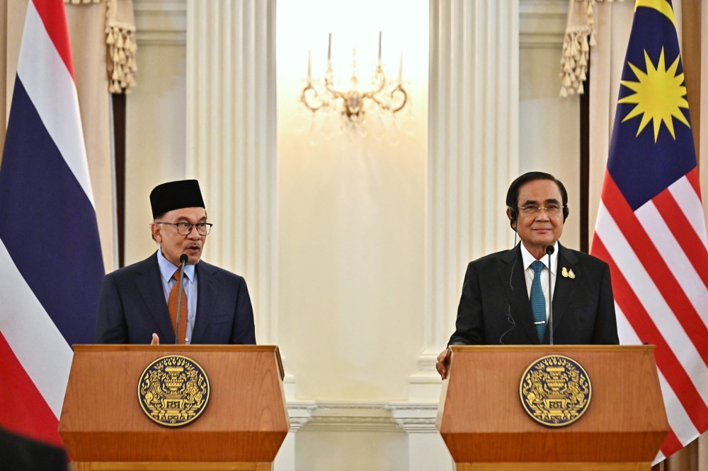 Malaysia's Prime Minister Anwar Ibrahim (L) and Thailand's Prime Minister Prayut Chan-O-Cha (R) attend a joint press conference during an official state visit at Government House in Bangkok on February 9, 2023. (Photo by Lillian SUWANRUMPHA / AFP)