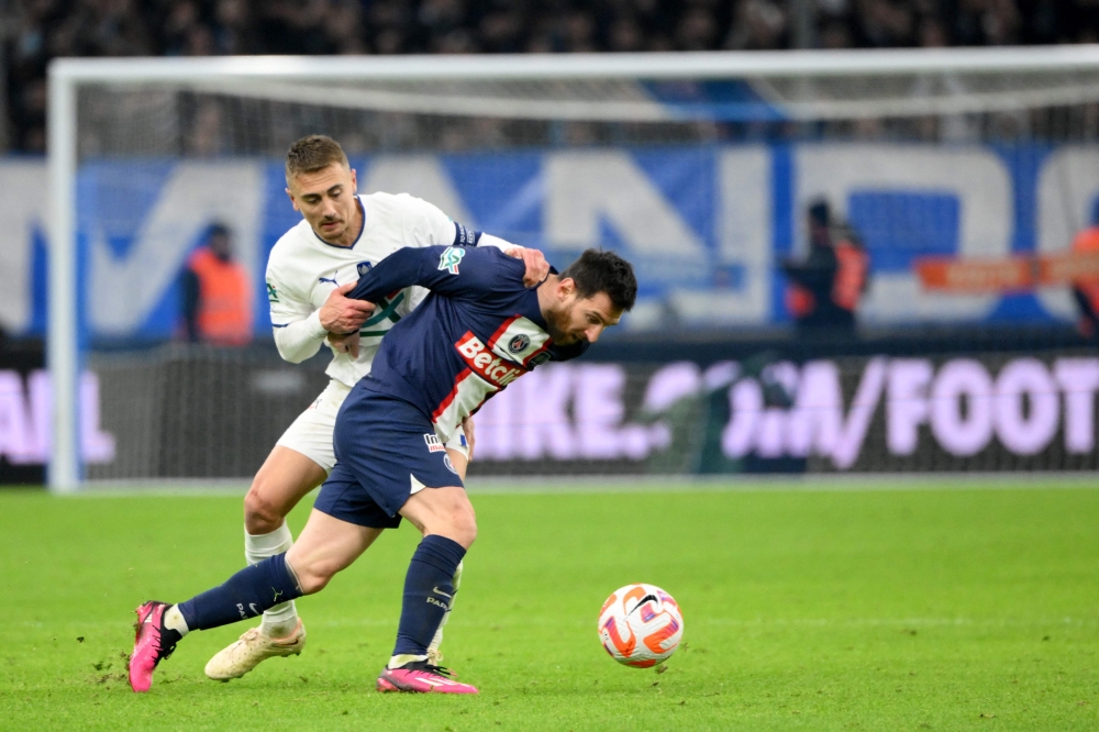 Marseille's French midfielder Valentin Rongier (left) fights for the ball with Paris Saint-Germain's Argentine forward Lionel Messi during the French Cup round of 16 football match between Olympique Marseille (OM) and Paris Saint-Germain (PSG) at Stade Velodrome in Marseille, southern France on February 8, 2023. (Photo by NICOLAS TUCAT / AFP)