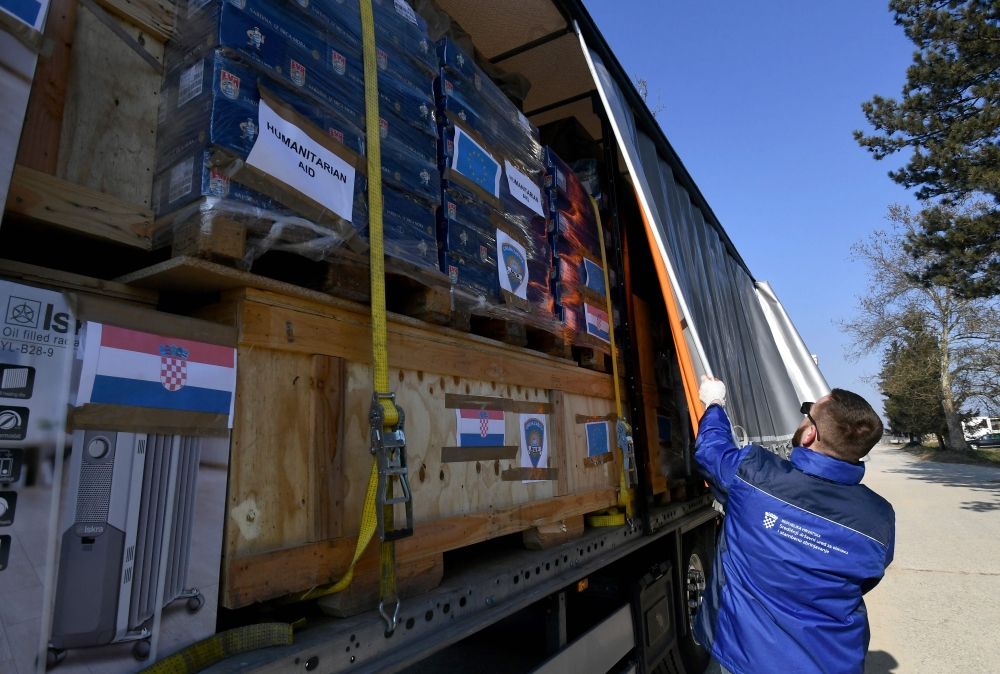 A driver closes the tarpaulin of a truck, containing humanitarian aid collected by Croatian government, Caritas and the Croatian Red Cross and lining-up at the logistics center of the directorate of civil protection in Jastrebarsk, near Zagreb, on February 10, 2023, ready to deliver to areas of Turkey after a 7.8-magnitude earthquake struck early February 6 near the Turkish-Syrian border. (Photo by DENIS LOVROVIC / AFP)