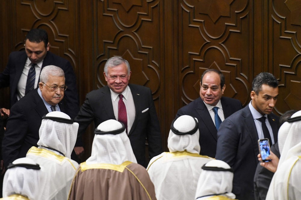 Palestinian President Mahmud Abbas (second left), Jordan's King Abdullah II (center), and Egyptian President Abdel Fattah al-Sisi (second right) talk to delegates during the Arab League's 