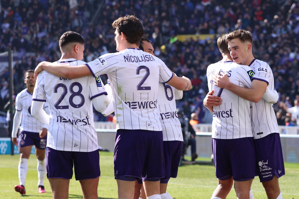 Toulouse's Dutch forward Thijs Dallinga (right) celebrates with teammates after scoring the third goal during the French L1 match between Toulouse FC and Stade Rennais FC at The TFC Stadium in Toulouse, southwestern France, on February 12, 2023. (Photo by Charly TRIBALLEAU / AFP)