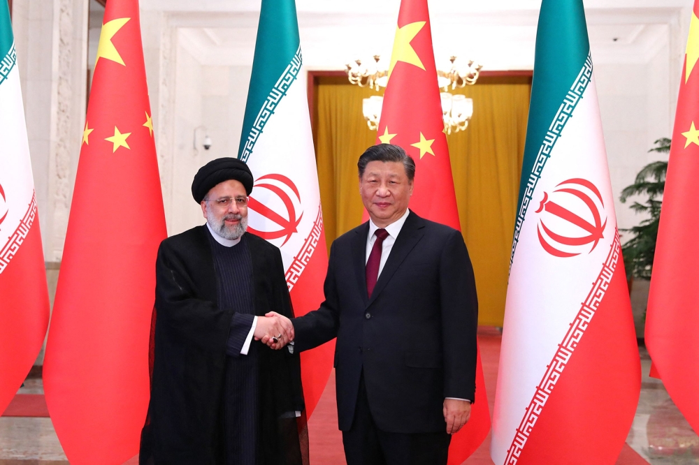 This handout picture provided by the Iranian presidency shows Chinese President Xi Jinping welcoming the Islamic Republic's President Ebrahim Raisi (L) during his visit in Beijing on February 14, 2023. (Photo by Iranian Presidency / AFP)