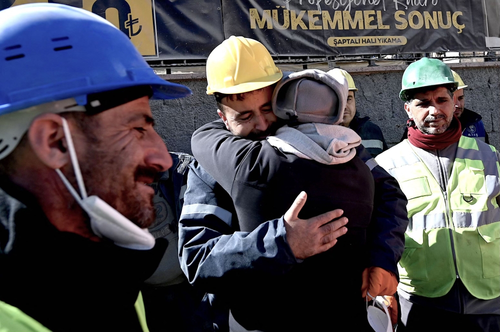 The uncle of Aleyna Olmez (C), reacts after the 17-year-old woman was rescued from a collapsed building, 248 hours after the 7.8-magnitude earthquake which struck parts of Turkey and Syria, in Kahramanmaras on February 16, 2023. (Photo by OZAN KOSE / AFP)