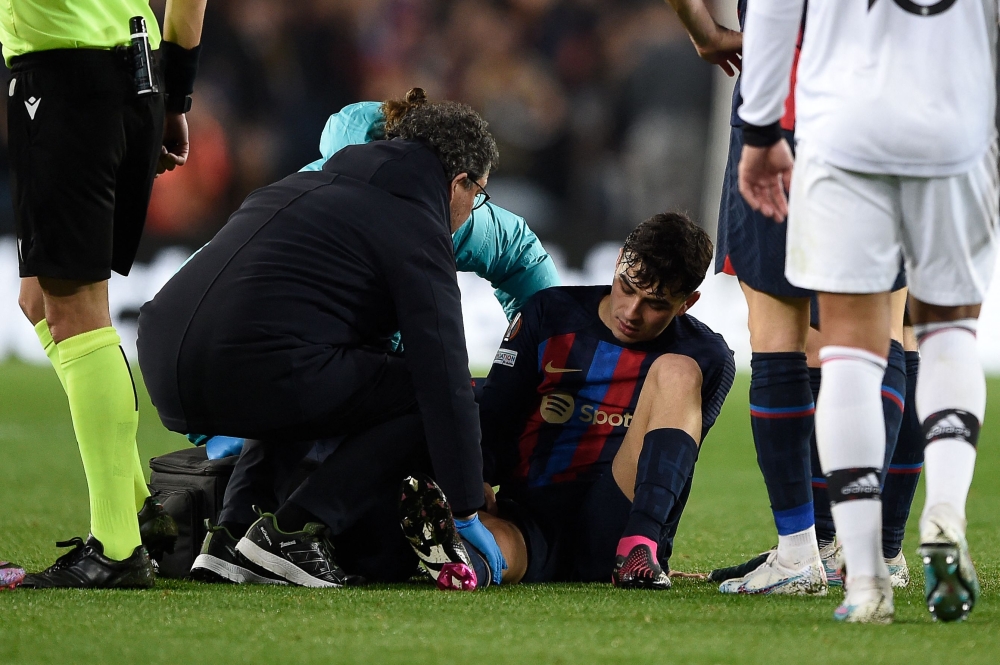 Barcelona's Spanish midfielder Pedri receives medical attention after a fall during the UEFA Europa League round of 32 first-leg football match between FC Barcelona and Manchester United at the Camp Nou stadium in Barcelona, on February 16, 2023. (Photo by Josep LAGO / AFP)

