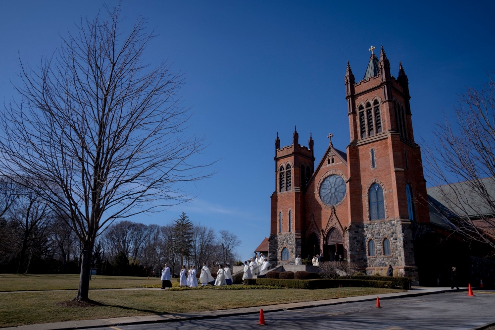 GROSSE POINTE, MI - FEBRUARY 18: Clergy lead the casket out after the funeral for Brian Fraser on February 18, 2023 at St. Paul on the Lake Catholic Church in Grosse Pointe Farms, Michigan. Brian Fraser was one of three students killed in the shooting that occurred at Michigan State University on Monday, February 13, 2023. Nic Antaya/Getty Images/AFP (Photo by Nic Antaya / GETTY IMAGES NORTH AMERICA / Getty Images via AFP)
