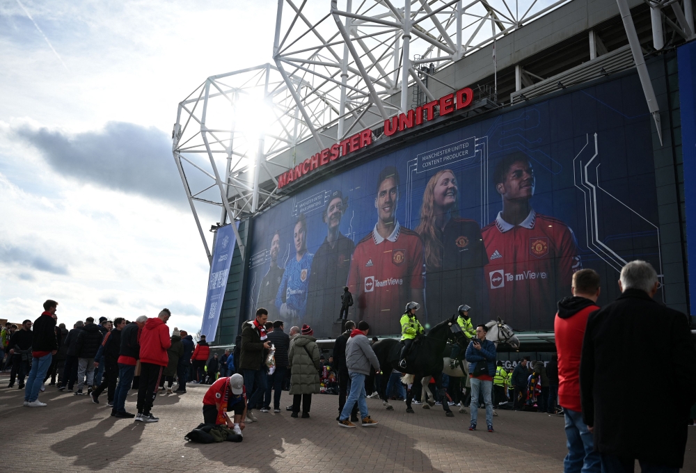 Fans pose for photos outside of Old Trafford stadium in Manchester north west England, ahead of the English Premier League football match between Manchester United and Leicester City, on February 19, 2023.  (Photo by Oli SCARFF / AFP)