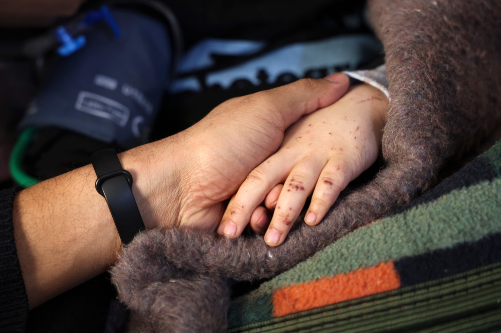 Syrian girl Sham Sheikh Mohammad, 9, who was rescued after fourty hours under the rubble of a deadly earthquake, lies on a hospital bed in the rebel-held northwestern city of Idlib, on February 17, 2023.  (Photo by Omar HAJ KADOUR / AFP)
 