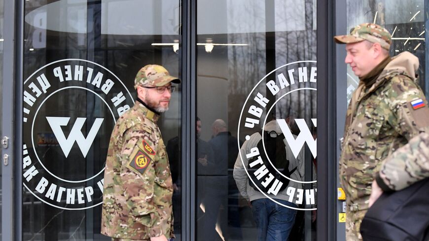 Visitors wearing military camouflage stand at the entrance of the 'PMC Wagner Centre', associated with the founder of the Wagner private military group (PMC) Yevgeny Prigozhin, during the official opening of the office block on the National Unity Day, in Saint Petersburg, on November 4, 2022. (Photo by OLGA MALTSEVA/AFP via Getty Images) 