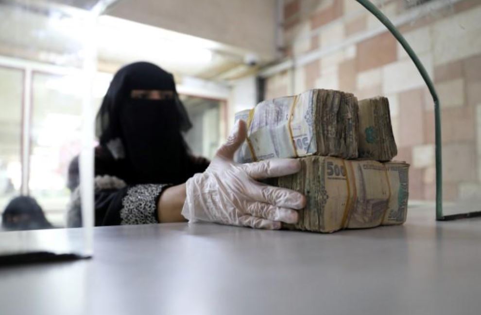 File Photo: An employee takes bundles of Yemeni Riyal. (REUTERS/Khaled Abdullah)