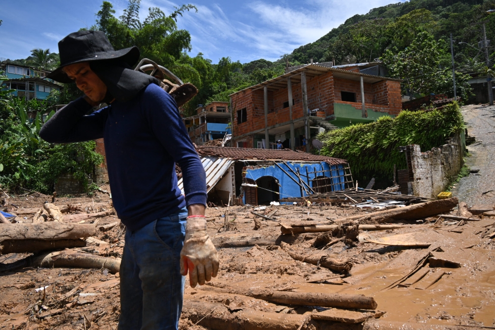 A man is seen at a flood-affected area in Barra do Sahy, Sao Sebastiao district, Sao Paulo state, Brazil on February 21, 2023. - Lifeguards continued to search for survivors on the Sao Paulo coast, where the heaviest rains in Brazil's history left at least 44 dead and dozens missing over the weekend, authorities said Tuesday. (Photo by NELSON ALMEIDA / AFP)
 