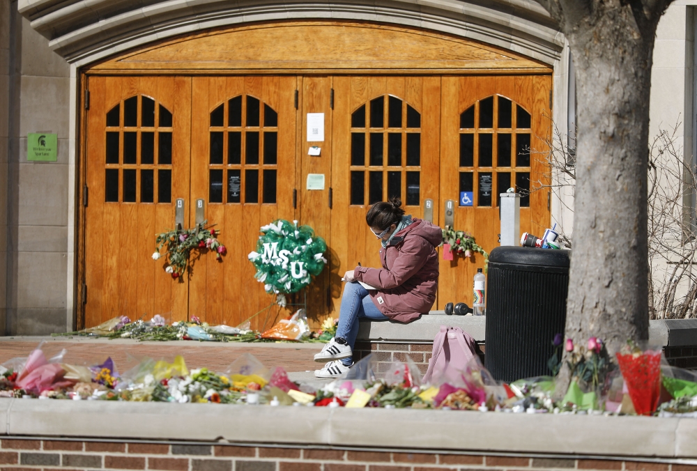 EAST LANSING, MI - FEBRUARY 20: A woman sits at Berkey Hall while Michigan State University students return to classes for the first time since the February 13 mass shooting there on February 20, 2023 in East Lansing, Michigan. The gunman shot 8 students on the campus of MSU, killing 3 of them, one of them at Berkey Hall.. Approximately 50,000 students are enrolled at Michigan State. Bill Pugliano/Getty Images/AFP (Photo by BILL PUGLIANO / GETTY IMAGES NORTH AMERICA / Getty Images via AFP)