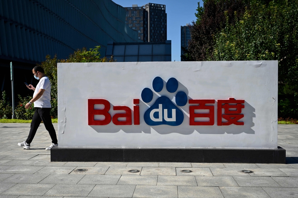 This file photo taken on September 6, 2022 shows an employee walking past the company logo at Baidu's headquarters in Beijing. Photo by Jade GAO / AFP