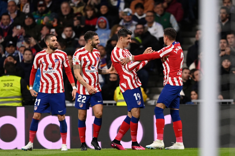 Atletico Madrid's defender Jose Gimenez (right) celebrates with teammates scoring his team's first goal during the Spanish League match between Real Madrid CF and Club Atletico de Madrid at the Santiago Bernabeu stadium in Madrid, on February 25, 2023. (Photo by OSCAR DEL POZO / AFP)