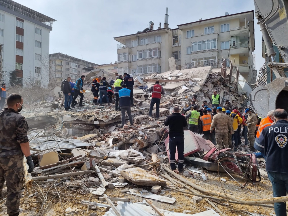 Rescuers carry on search operations among the rubble of collapsed buildings in the Yesilyurt district of Malatya on February 27, 2023. (Photo by Demiroren News Agency / AFP) 