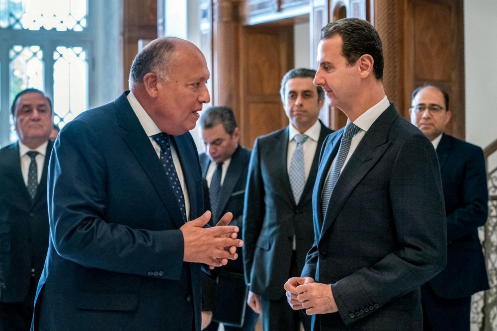 This handout picture released by the Egyptian Foreign Ministry shows Egypt's Foreign Minister Sameh Shoukry (left) meeting with Syrian President Bashar al-Assad in Damascus on February 27, 2023. (AFP)