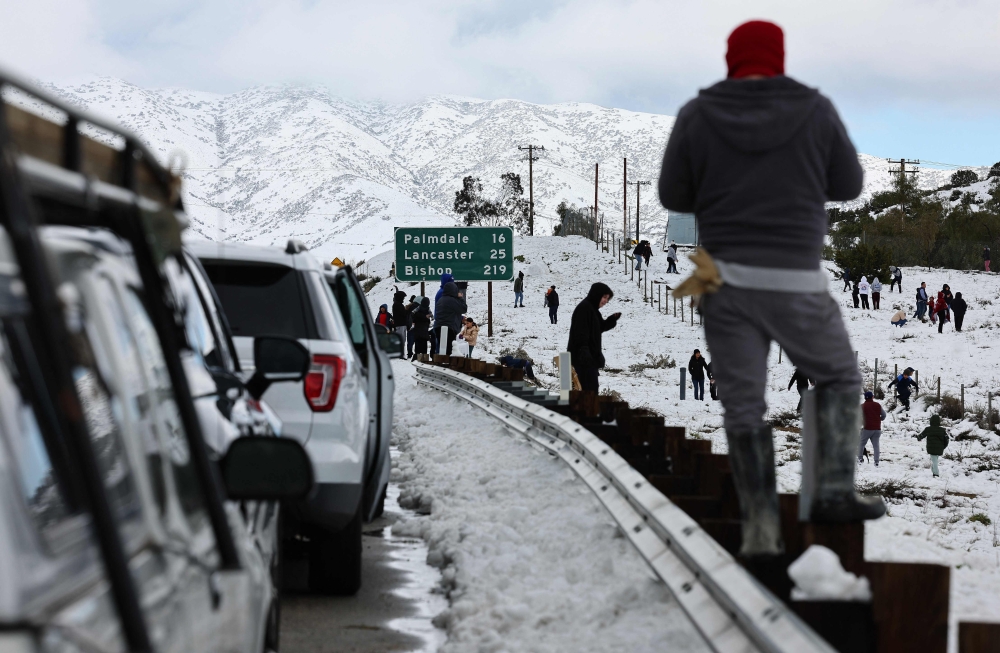 Cars are lined up after people parked on the side of the freeway to walk and play in the snow along Highway 14 in Los Angeles County on February 26, 2023 near Acton, California. Photo by MARIO TAMA / GETTY IMAGES NORTH AMERICA / Getty Images via AFP