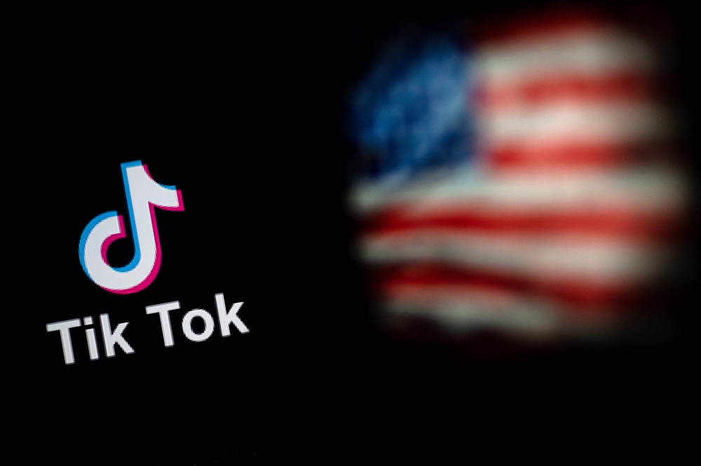 This file illustration photo taken on September 14, 2020 shows the logo of the social network application TikTok and a US flag shown on the screens of two laptops in Beijing. - The White House on Monday, February 28, 2023, gave federal agencies 30 days to purge Chinese-owned video-snippet sharing app TikTok from all government-issued devices, setting a deadline to comply with a ban ordered by the US Congress. (Photo by NICOLAS ASFOURI / AFP)