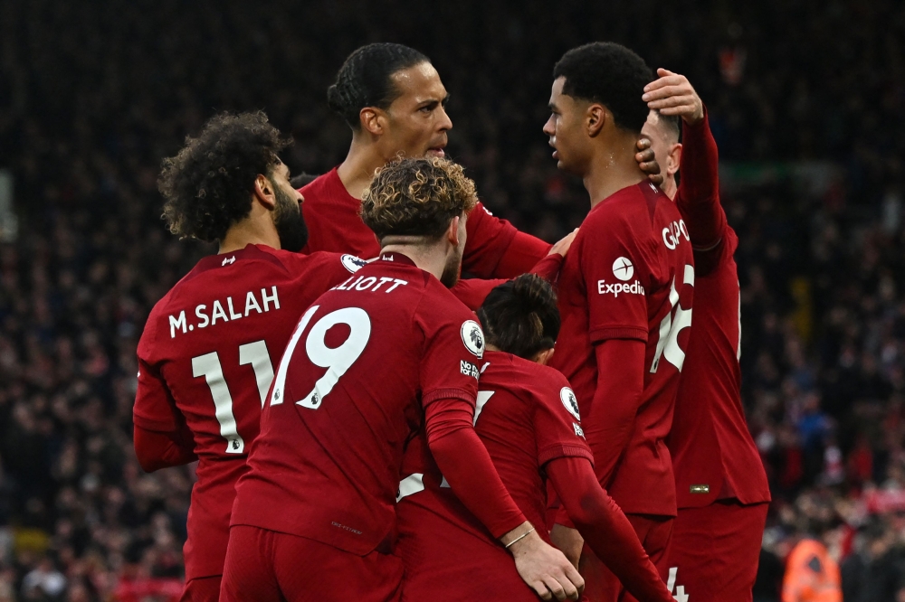 Liverpool's Dutch striker Cody Gakpo (second right) celebrates with teammates after scoring the opening goal of the English Premier League match between Liverpool and Manchester United at Anfield in Liverpool, north west England on March 5, 2023. (Photo by Paul ELLIS / AFP)