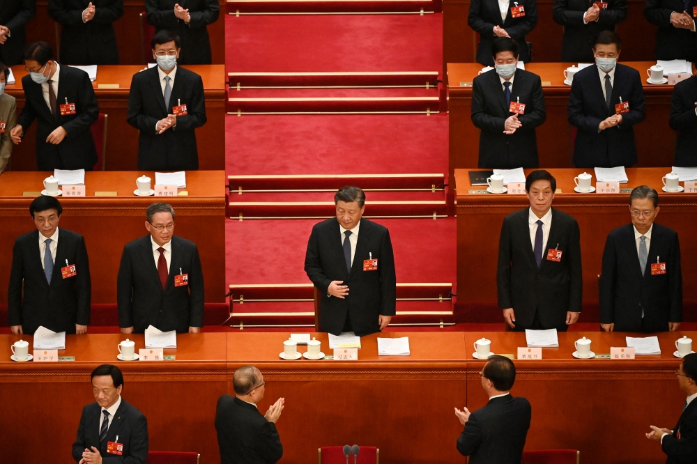 China's President Xi Jinping (C) is applauded as he arrives for the second plenary session of the National People's Congress (NPC) at the Great Hall of the People in Beijing on March 7, 2023. (Photo by Greg Baker / AFP)
