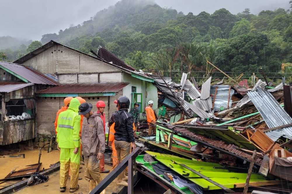 This handout photo taken and released on March 7, 2023 by the Natuna ministry of communication and information local office shows a rescue team inspecting damages and searching for victims following landslides in Natuna islands. (Photo by Handout / Natuna ministry of communication / AFP)