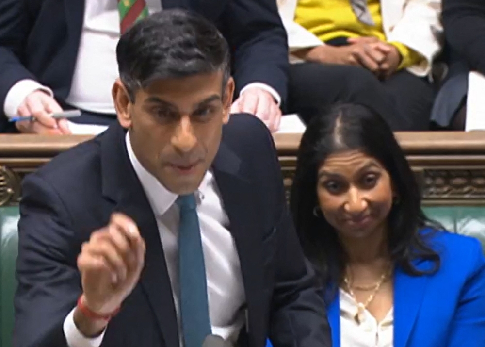 A video grab from footage broadcast by the UK Parliament's Parliamentary Recording Unit (PRU) shows Britain's Home Secretary Suella Braverman (right) listening as Britain's Prime Minister Rishi Sunak speaks during the weekly session of Prime Minister's Questions (PMQs) in the House of Commons in London on March 8, 2023. (Photo by Handout / PRU / AFP) 