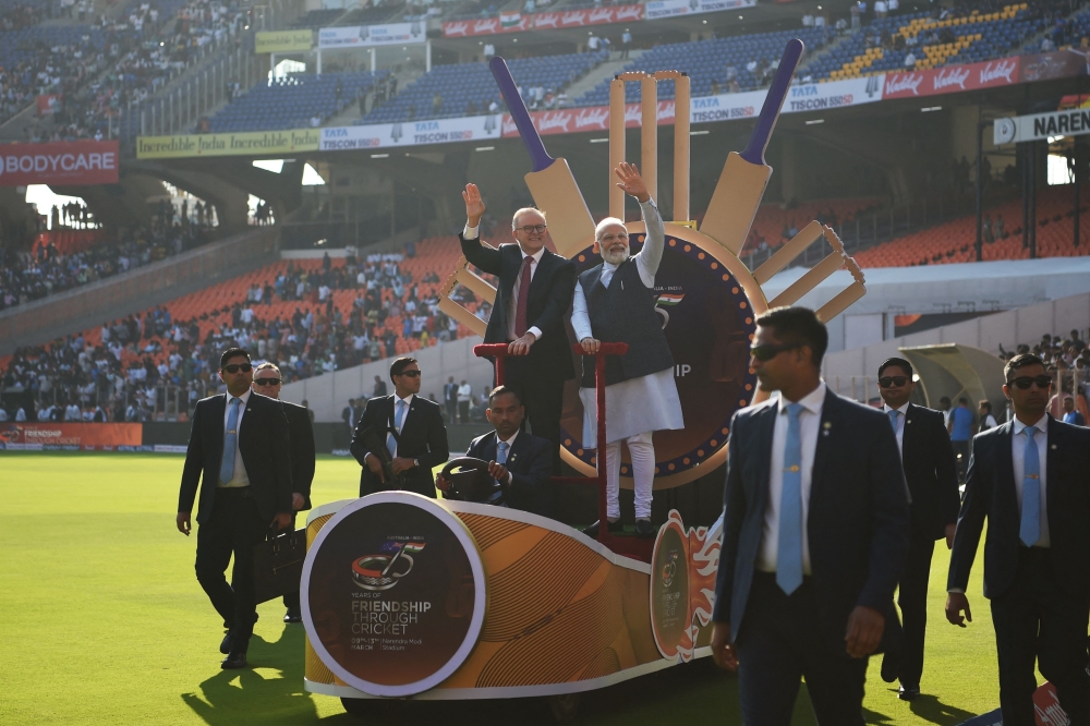 Indian Prime Minister Narendra Modi and Australia's Prime Minister Anthony Albanese wave to spectators from atop a float at the Narendra Modi stadium in Ahmedabad on March 9, 2023, before the start of the fourth and final Test cricket match between India and Australia. (Photo by Punit PARANJPE / AFP)