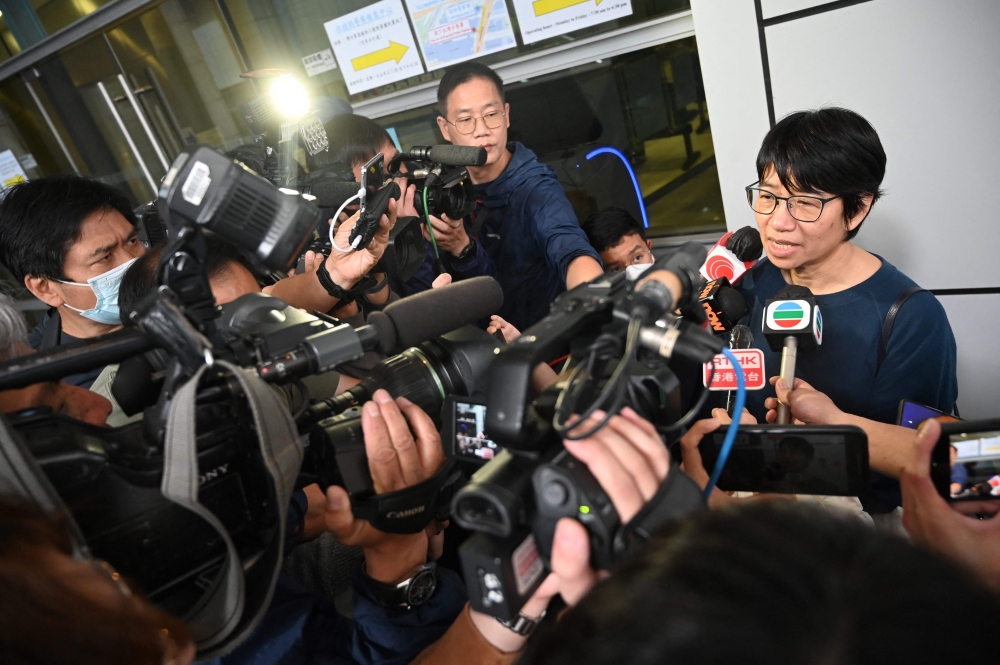 Elizabeth Tang Yin-ngor (right), secretary-general of the International Domestic Workers Federation, speaks to the media as she leaves the Wan Chai police headquarters in Hong Kong on March 11, 2023 after posting bail following her arrest on March 9, 2023 on suspicion of 