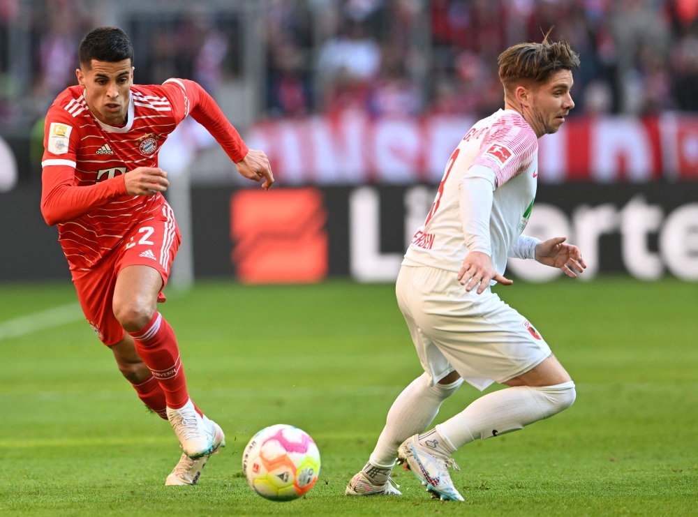 Bayern Munich's Portuguese midfielder Joao Cancelo (L) and Augsburg's Danish defender Mads Pedersen vie for the ball during the German first division Bundesliga football match between Bayern Munich and Augsburg in Munich on March 11, 2023. (Photo by Christof STACHE / AFP) 