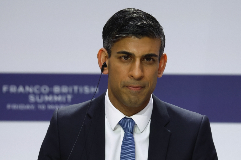 British Prime Minister Rishi Sunak listens during a joint press conference with French President as part of the Franco-British Summit held at the Elysee Palace in Paris, on March 10, 2023. (Photo by GONZALO FUENTES / POOL / AFP)