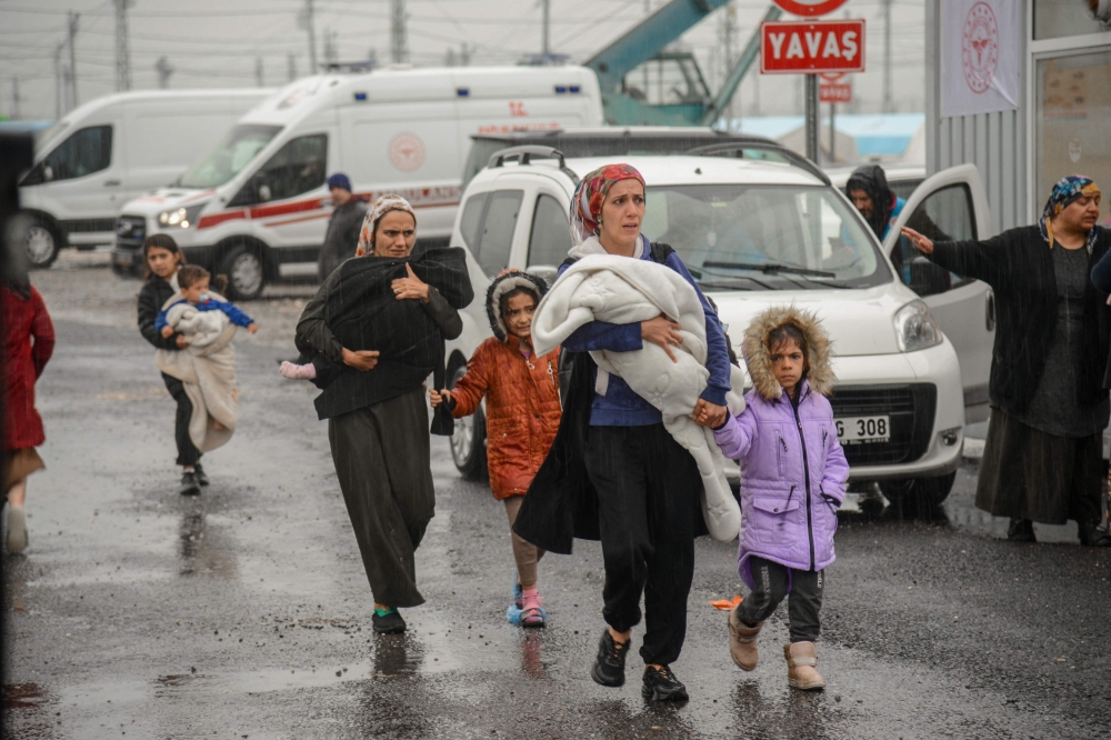 A family leaves a camp for those displaced after the February 6 earthquake, during heavy rains in Diyarbakir, on March 15, 2023. (Photo by ILYAS AKENGIN / AFP)