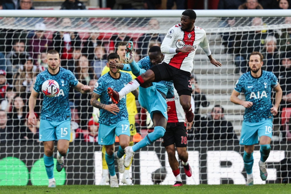 Southampton's English midfielder Ainsley Maitland-Niles (centre) is tackled and is awarded a penalty during the English Premier League football match between Southampton and Tottenham Hotspur at St Mary's Stadium in Southampton, southern England on March 18, 2023. (Photo by Adrian DENNIS / AFP)