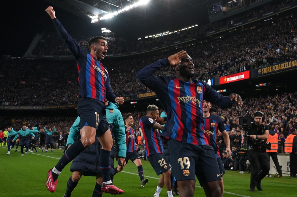 Barcelona's Ivorian midfielder Franck Kessie celebrates with teammates after scoring his team's second goal during the Spanish league football match between FC Barcelona and Real Madrid CF at the Camp Nou stadium in Barcelona on March 19, 2023. Photo by LLUIS GENE / AFP
