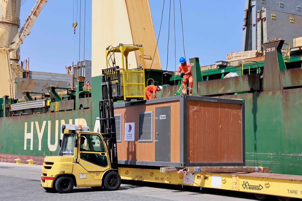 Workers load cabins and caravans used during the football World Cup in Qatar onto a cargo ship slated for departure from Hamad Port, on March 20, 2023, as a donation to Turkey and Syria to house people who lost their homes in a devastating earthquake in early February. (Photo by KARIM JAAFAR / AFP)