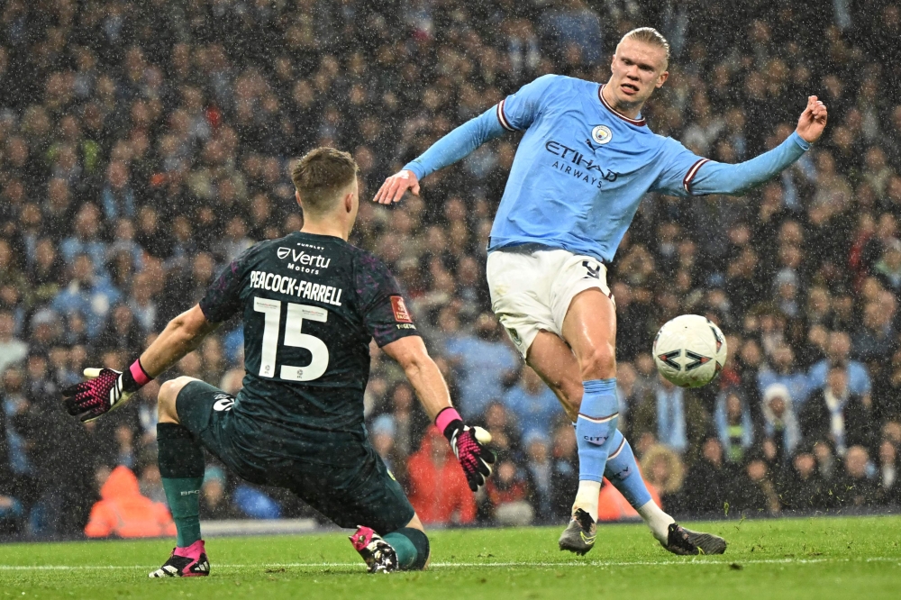 Manchester City's Norwegian striker Erling Haaland scores their second goal past Burnley's Northern Irish goalkeeper Bailey Peacock-Farrell during the English FA Cup quarter-final football match between Manchester City and Burnley at the Etihad Stadium in Manchester, north-west England, on March 18, 2023. (Photo by Oli SCARFF / AFP)

