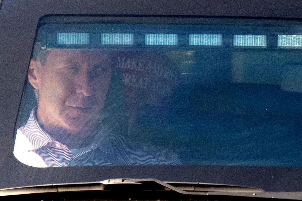 Former US President Donald Trump sits in the rear of his limousine as he leaves from Trump International Golf Club in Palm Beach, Florida, on March 23, 2023.  (Photo by CHANDAN KHANNA / AFP)