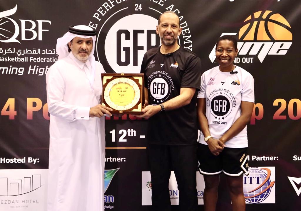 Engineer Ahmed Hammouda, Director General of Fame Sports Academy, presents a memento to QBF Secretary-General Saadoun Al Kuwari as a token of appreciation in the presence of coach Gigi Brown.