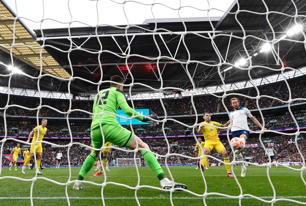 England's striker Harry Kane (R) scores his team's first goal during the UEFA Euro 2024 group C qualification football match between England and Ukraine at Wembley Stadium in London on March 26, 2023. (Photo by Glyn KIRK / AFP)