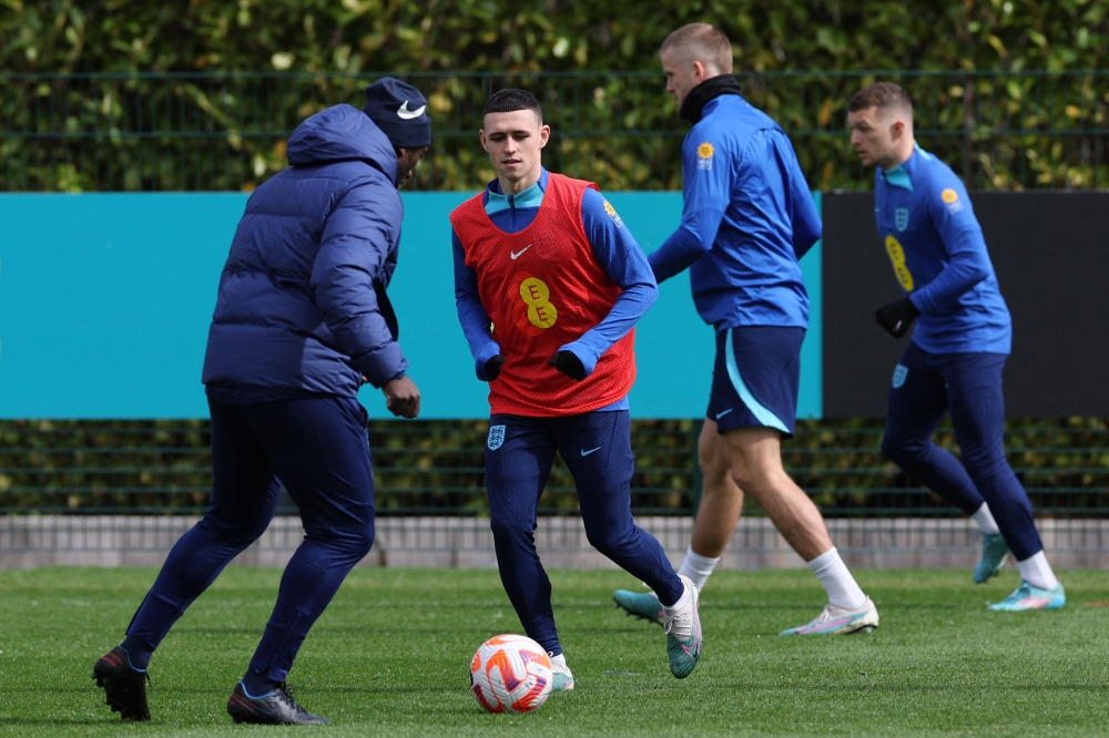 (Left to right) England's Dutch assistant coach Jimmy Floyd Hasselbaink, England's midfielder Phil Foden, England's midfielder Eric Dier and England's defender Kieran Trippier take part in an England football team training session at the Tottenham Hotspur Training Ground, in Enfield, north London on March 25, 2023, the eve of their Euro 2024 qualifier against Ukraine. (Photo by Adrian DENNIS / AFP)
